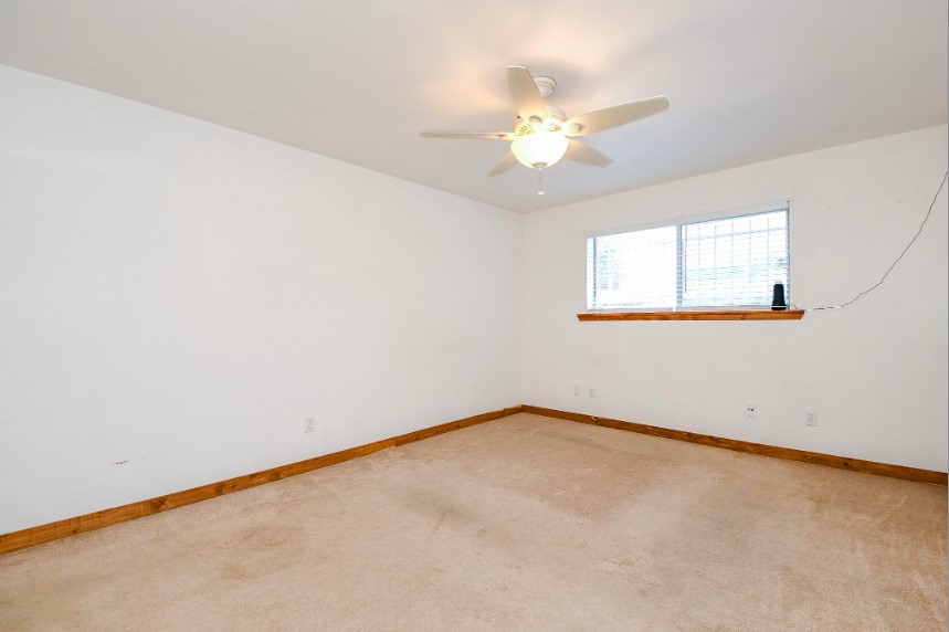 7233 Beechnut Street, Unit A Houston, TX 77074 - Photo 22 of 40 an empty room with a chandelier fan and windows