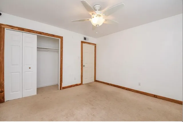 an empty room with a ceiling fan and a window