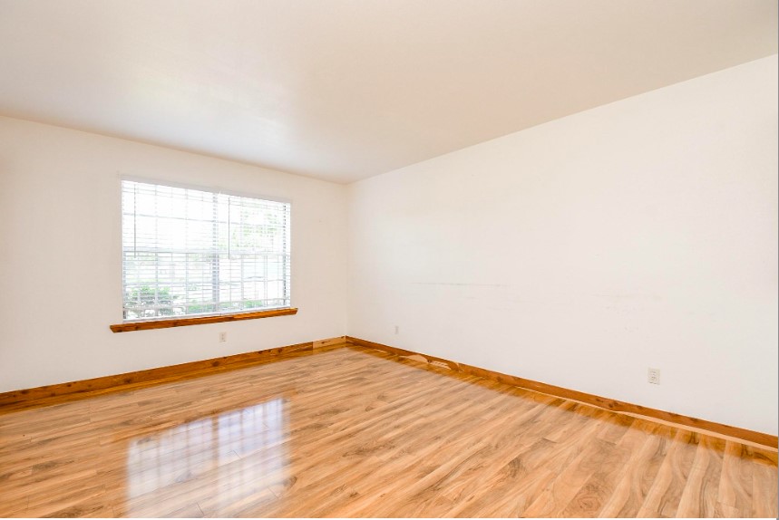 7233 Beechnut Street, Unit A Houston, TX 77074 - Photo 8 of 40 an empty room with wooden floor and windows