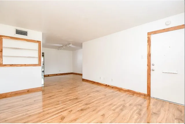 a view of empty room with wooden floor