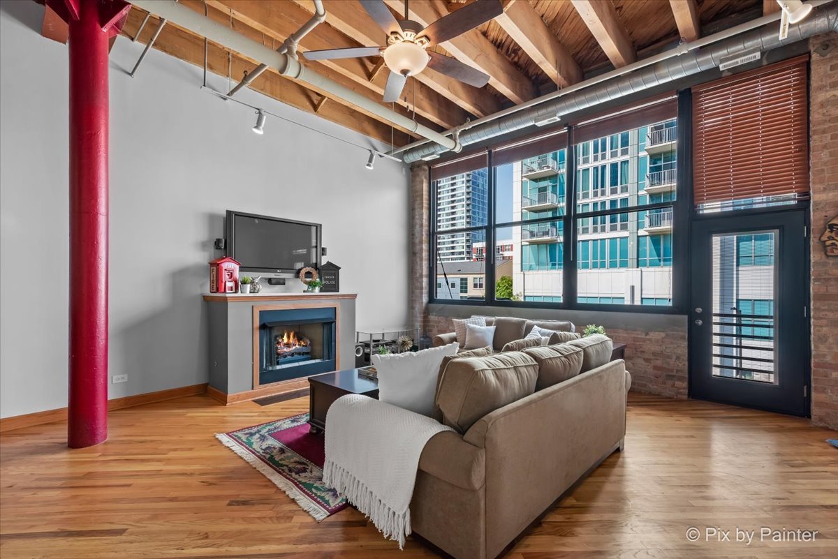 1601 South Indiana Avenue, Unit 306 Chicago, IL 60616 - Photo 9 of 25 a living room with furniture a fireplace and a flat screen tv