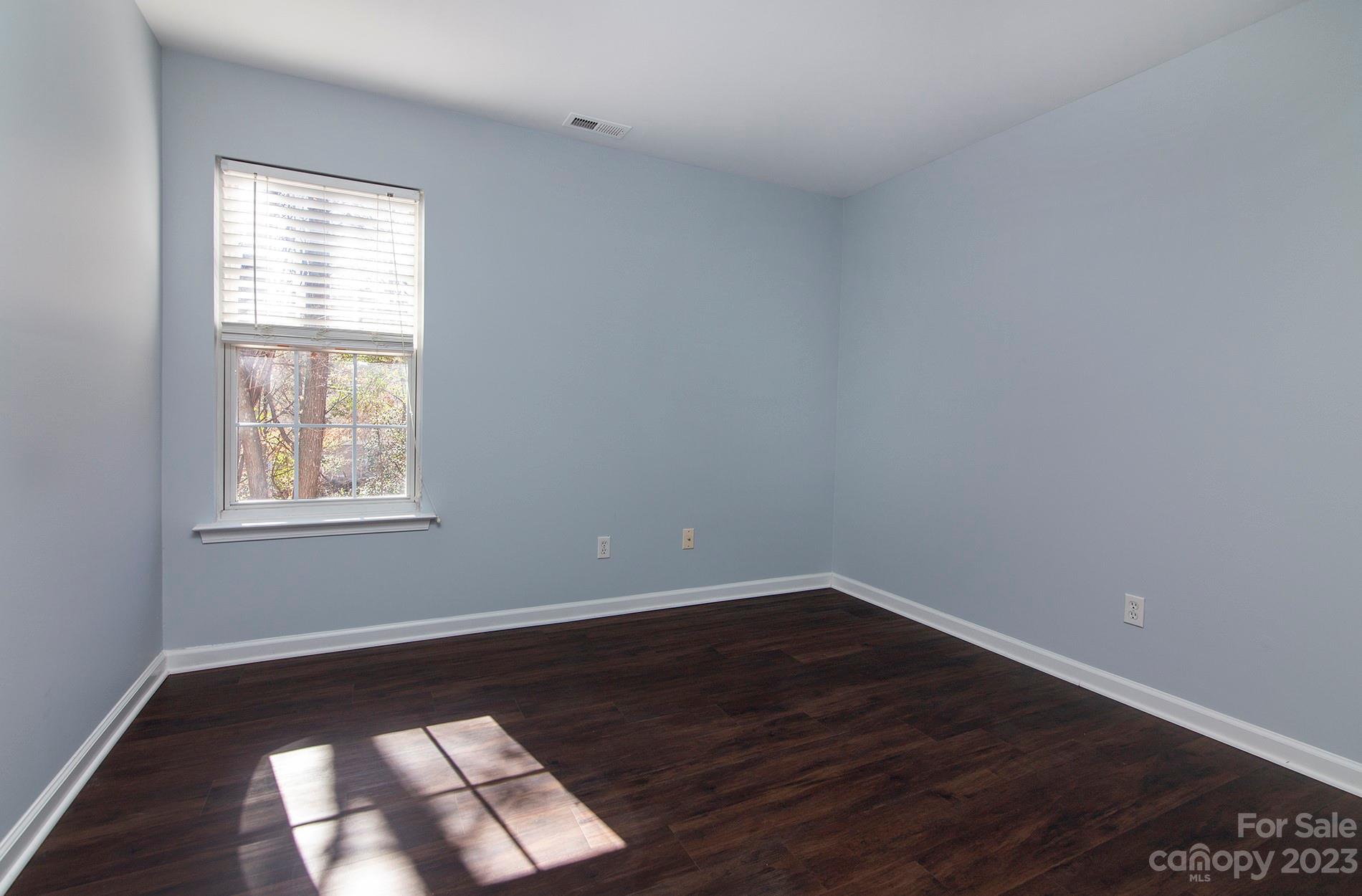 6112 Nevin Road Charlotte, NC 28262 - Photo 18 of 23 an empty room with wooden floor and windows