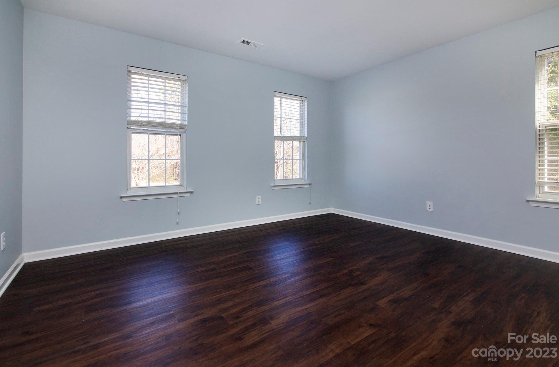 6112 Nevin Road Charlotte, NC 28262 - Photo 20 of 23 an empty room with wooden floor and windows