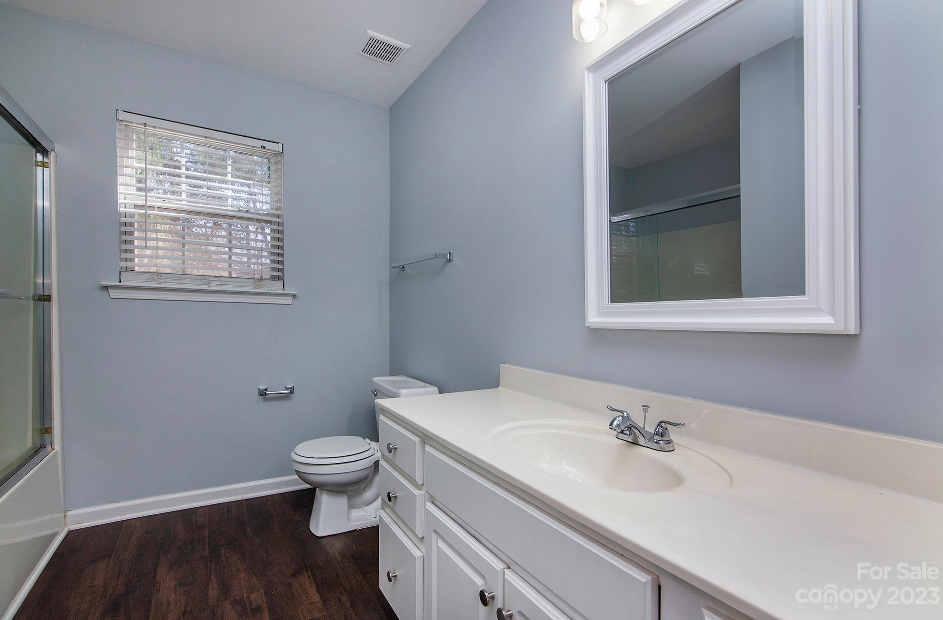 6112 Nevin Road Charlotte, NC 28262 - Photo 21 of 23 a bathroom with a granite countertop sink toilet and mirror