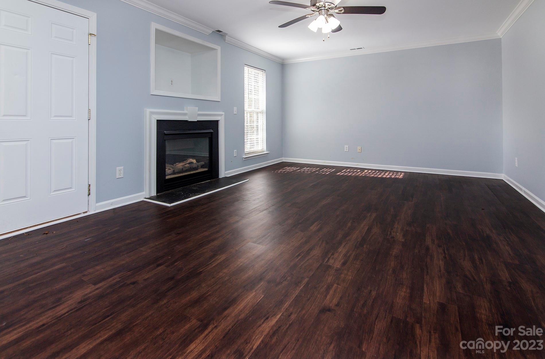 6112 Nevin Road Charlotte, NC 28262 - Photo 5 of 23 a view of an empty room with wooden floor and a fireplace