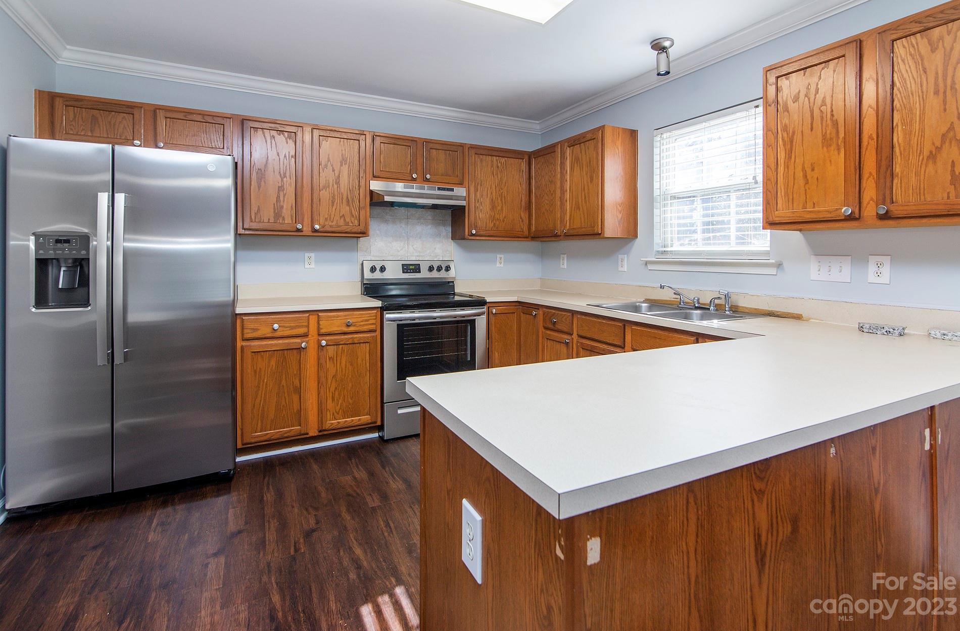 6112 Nevin Road Charlotte, NC 28262 - Photo 8 of 23 a kitchen with stainless steel appliances a sink a stove a refrigerator cabinets and a window