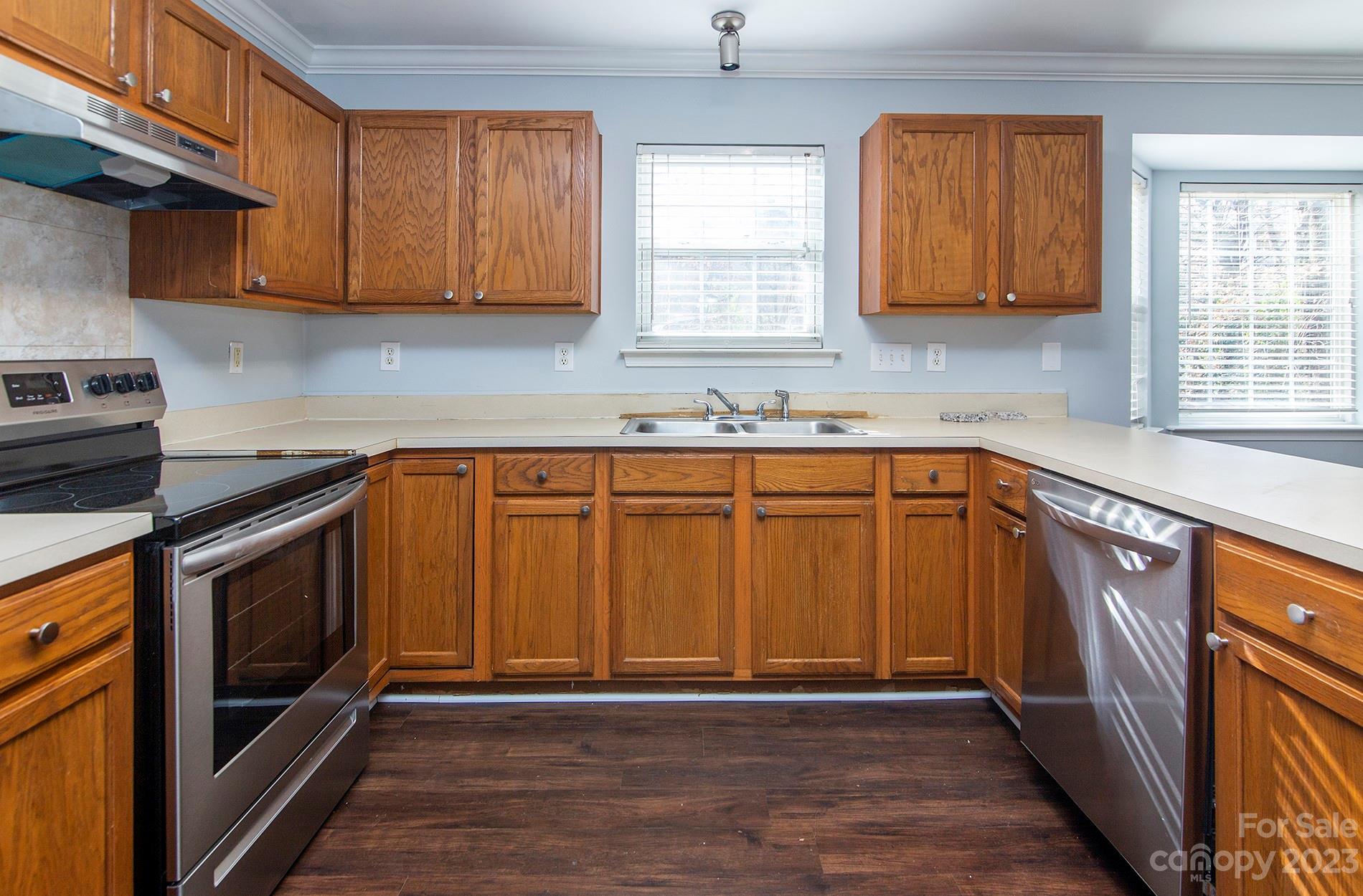 6112 Nevin Road Charlotte, NC 28262 - Photo 9 of 23 a kitchen with stainless steel appliances granite countertop wooden cabinets a sink and a stove