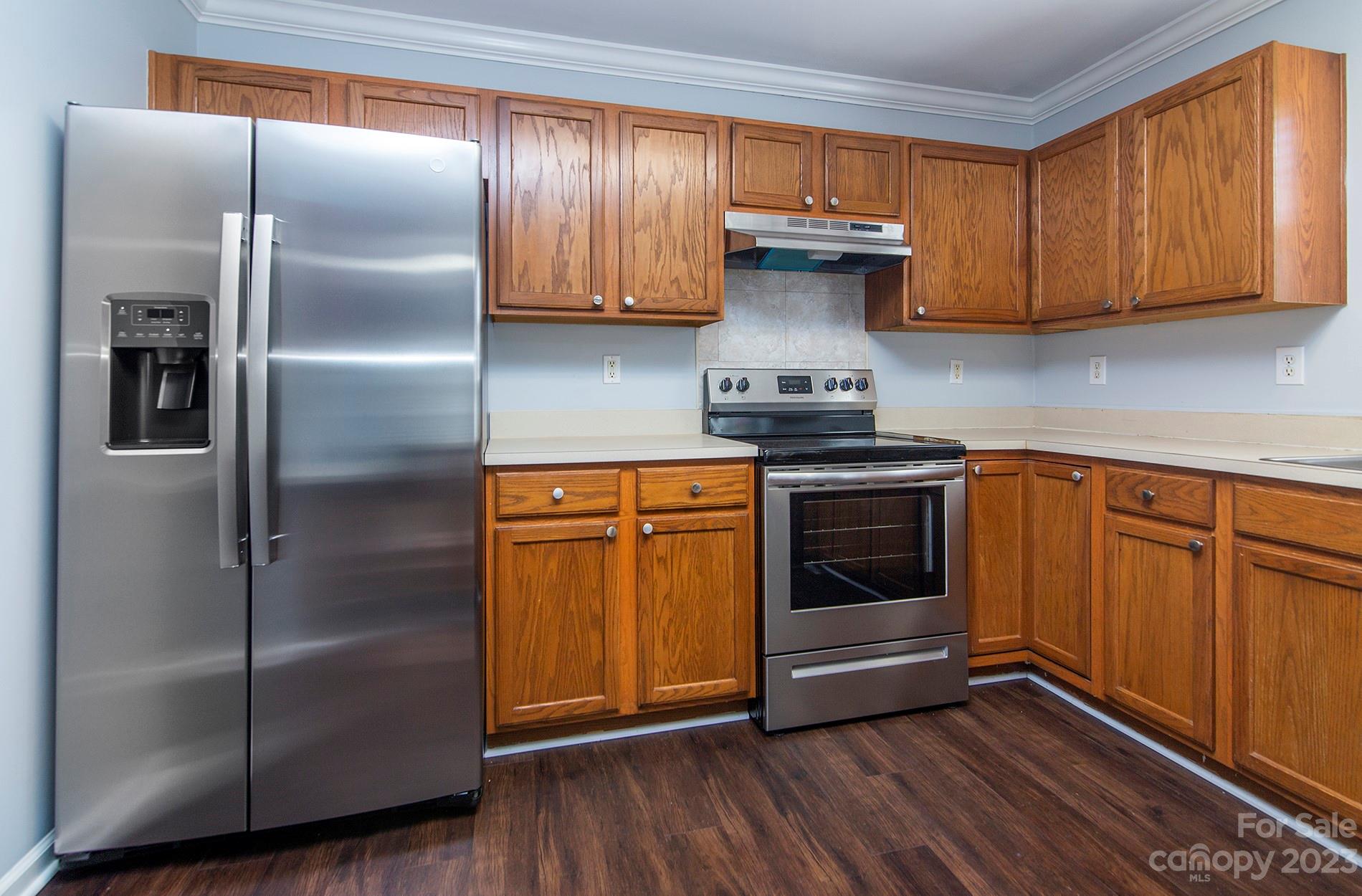 6112 Nevin Road Charlotte, NC 28262 - Photo 10 of 23 a kitchen with granite countertop stainless steel appliances a stove a refrigerator a sink and cabinets