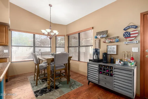 a view of a dining room with furniture a chandelier and wooden floor