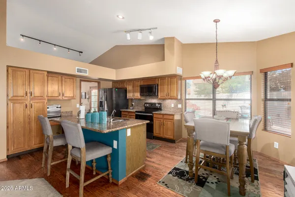 a room with stainless steel appliances kitchen island granite countertop furniture and a dining table