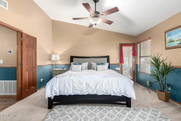 a bedroom with a large bed and a chandelier