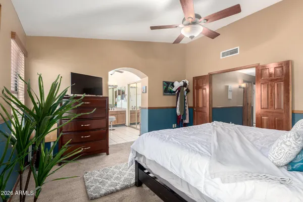 a spacious bedroom with a bed and a chandelier