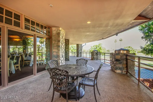 a patio with table and chairs and potted plants