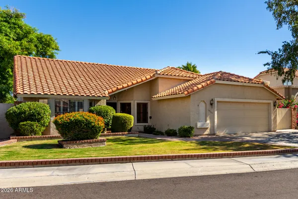 a front view of a house with a garden and plants