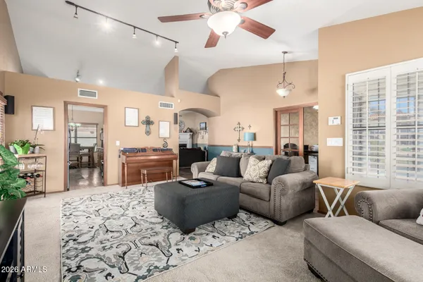 a living room with furniture kitchen view and a large window