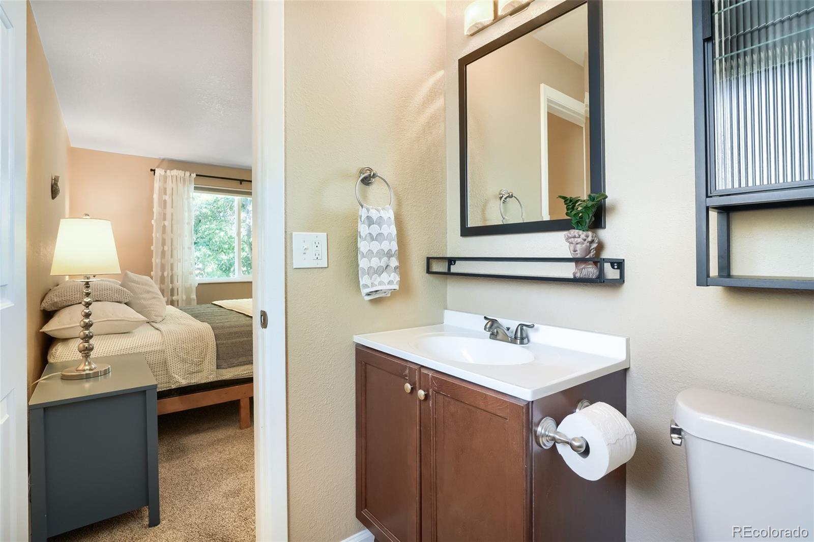 6551 South Albion Way Littleton, CO 80121 - Photo 14 of 37 a en suite bathroom with a toilet sink and mirror