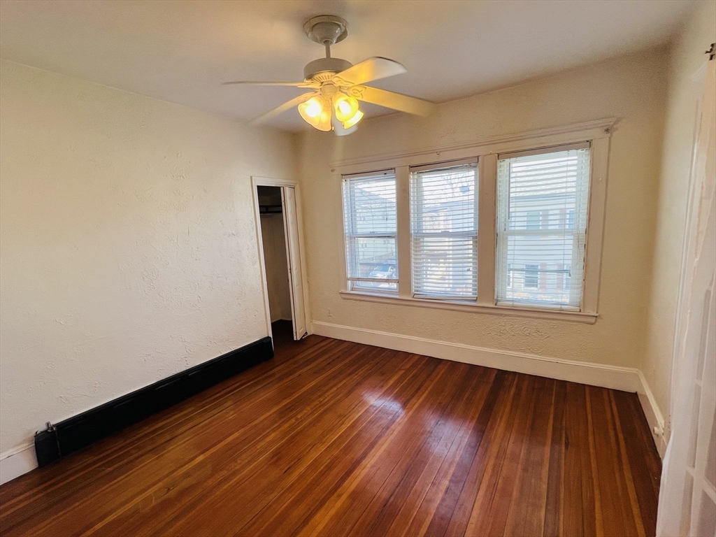 62 Westmore Road, Unit 2 Boston, MA 02126 - Photo 11 of 13 a view of an empty room with wooden floor and a window