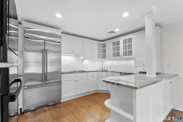 a kitchen with stainless steel appliances granite countertop a sink stove and refrigerator