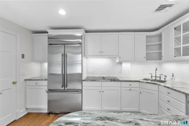 a kitchen with a refrigerator sink and cabinets