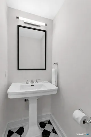 a bathroom with a toilet sink and mirror