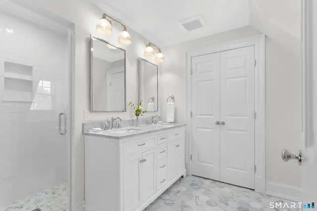 a bathroom with a granite countertop sink a mirror and a shower