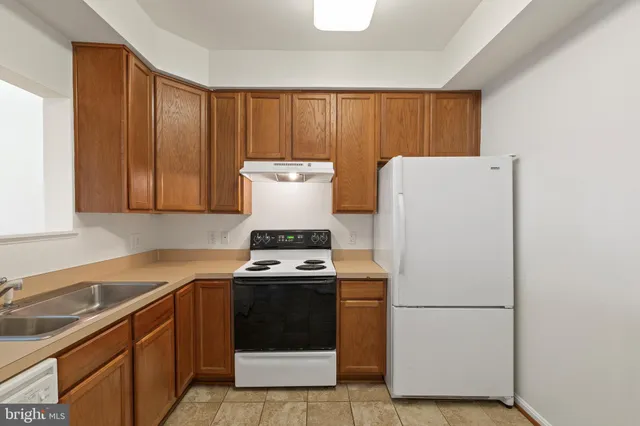 a kitchen with a stove a refrigerator and a sink