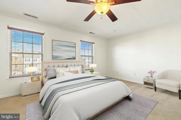 a bedroom with a large bed and a chandelier fan