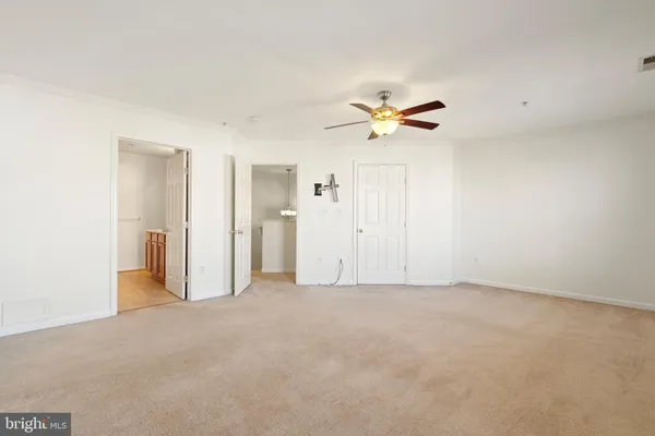 an empty room with closet and a ceiling fan