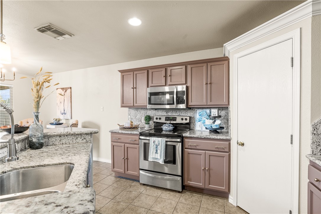 6630 Riding Wind Drive Corpus Christi, TX 78414 - Photo 12 of 40 a kitchen with stainless steel appliances granite countertop a sink stove and refrigerator