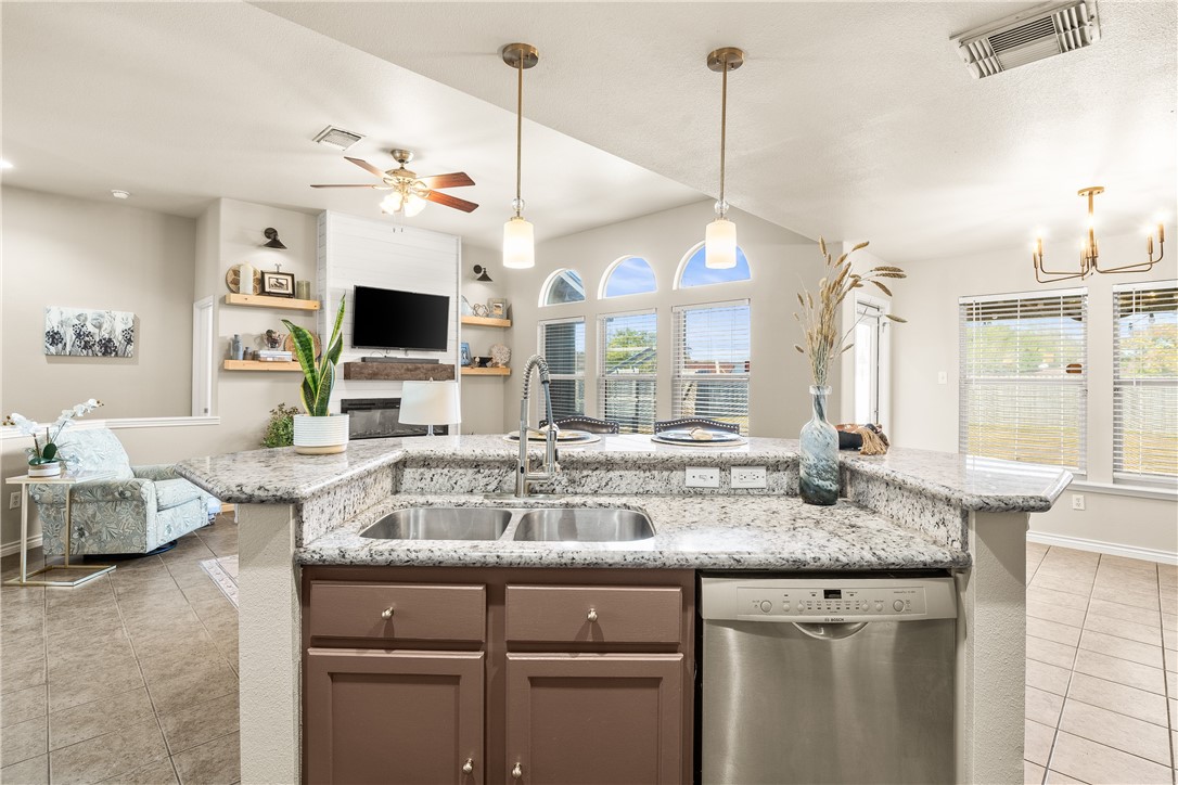 6630 Riding Wind Drive Corpus Christi, TX 78414 - Photo 13 of 40 a kitchen with kitchen island granite countertop a sink and a flat screen tv