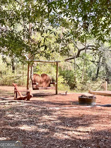 a view of a house with backyard and trees