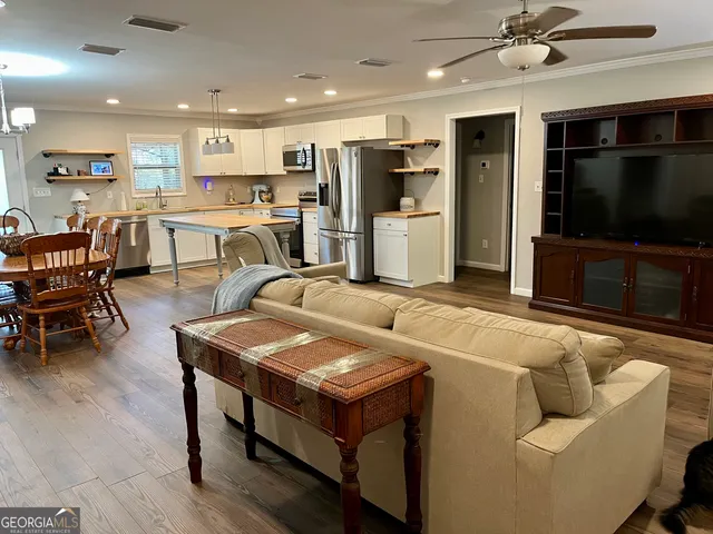 a living room with stainless steel appliances kitchen island granite countertop furniture and a view of kitchen