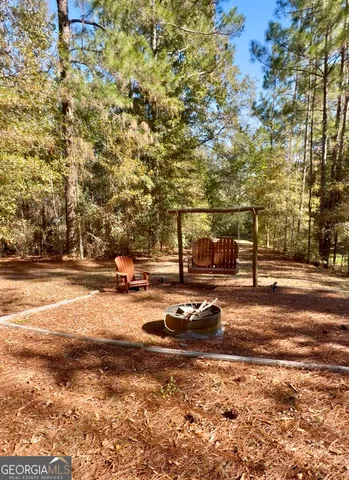 a view of dirt yard with large trees