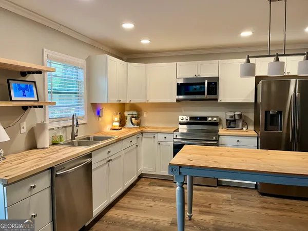 a kitchen with stainless steel appliances wooden cabinets a sink and a stove