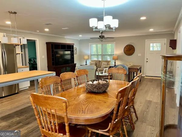 a view of a dining room with furniture a chandelier and wooden floor