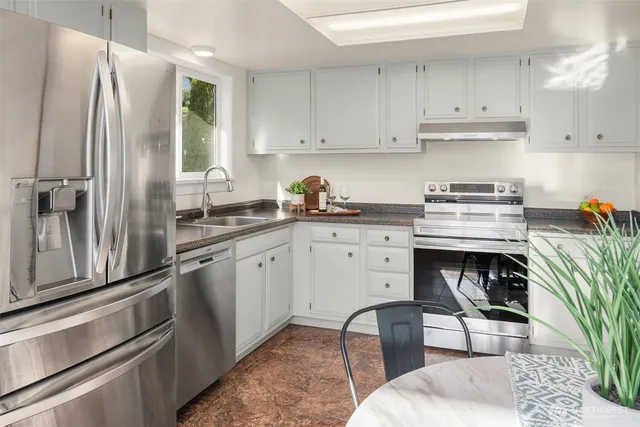 a kitchen with a sink appliances and cabinets