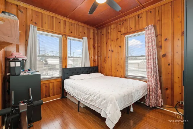 a bedroom with a bed and wooden floor