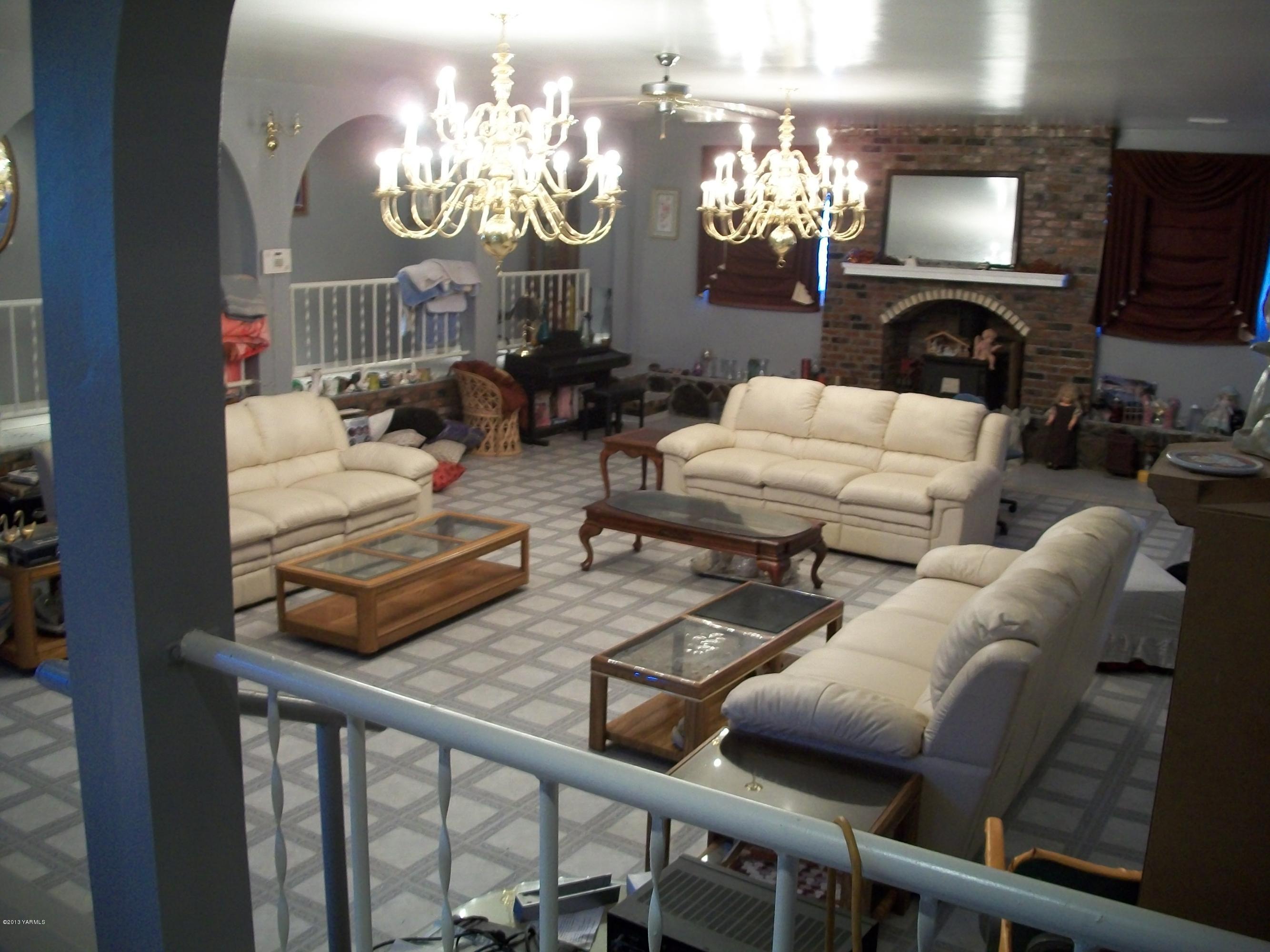 7600 Fort Road Wapato, WA 98951 - Photo 26 of 50 a living room with furniture a chandelier and a fireplace