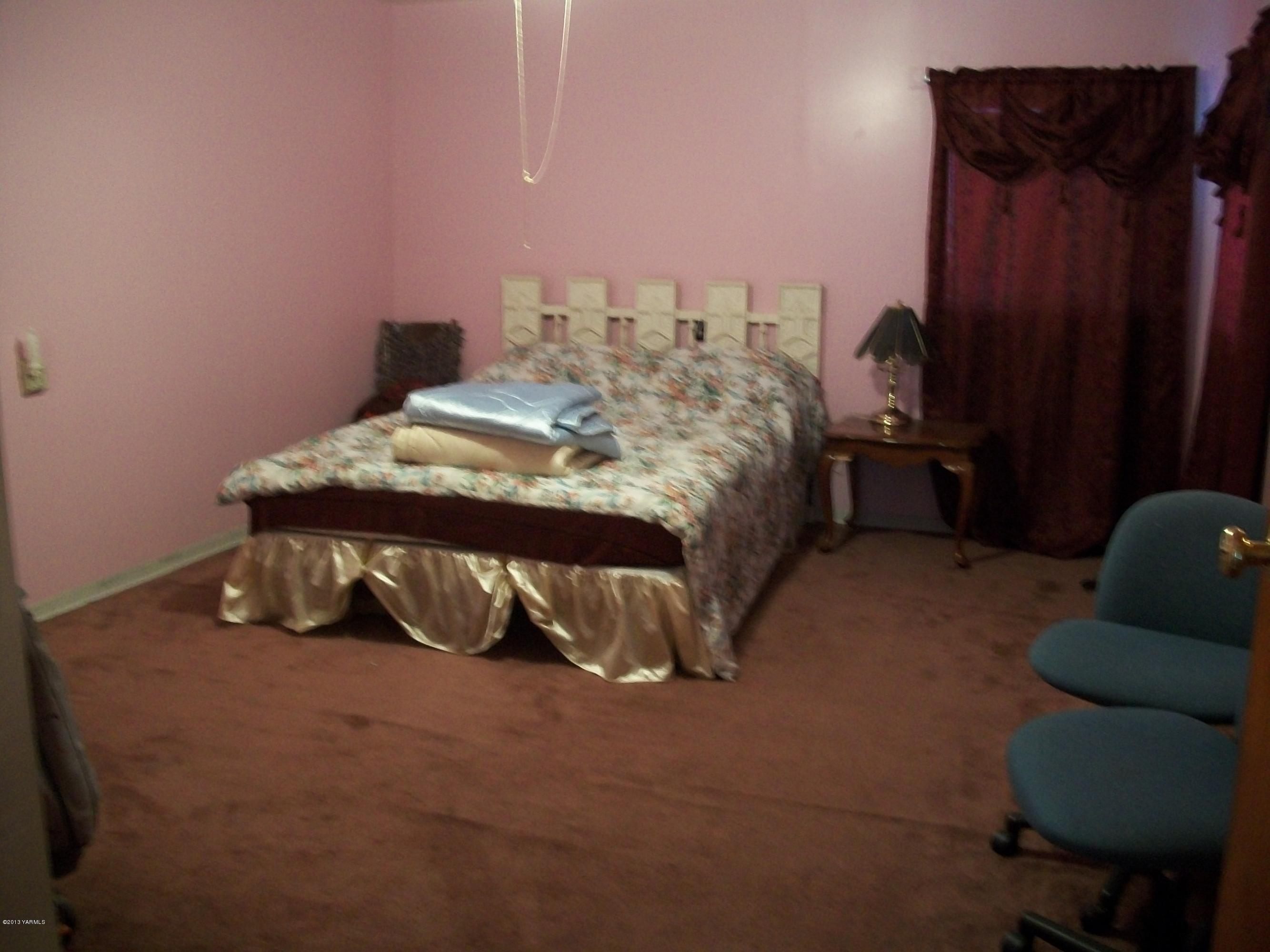 7600 Fort Road Wapato, WA 98951 - Photo 30 of 50 a bed sitting in a bedroom next to a window