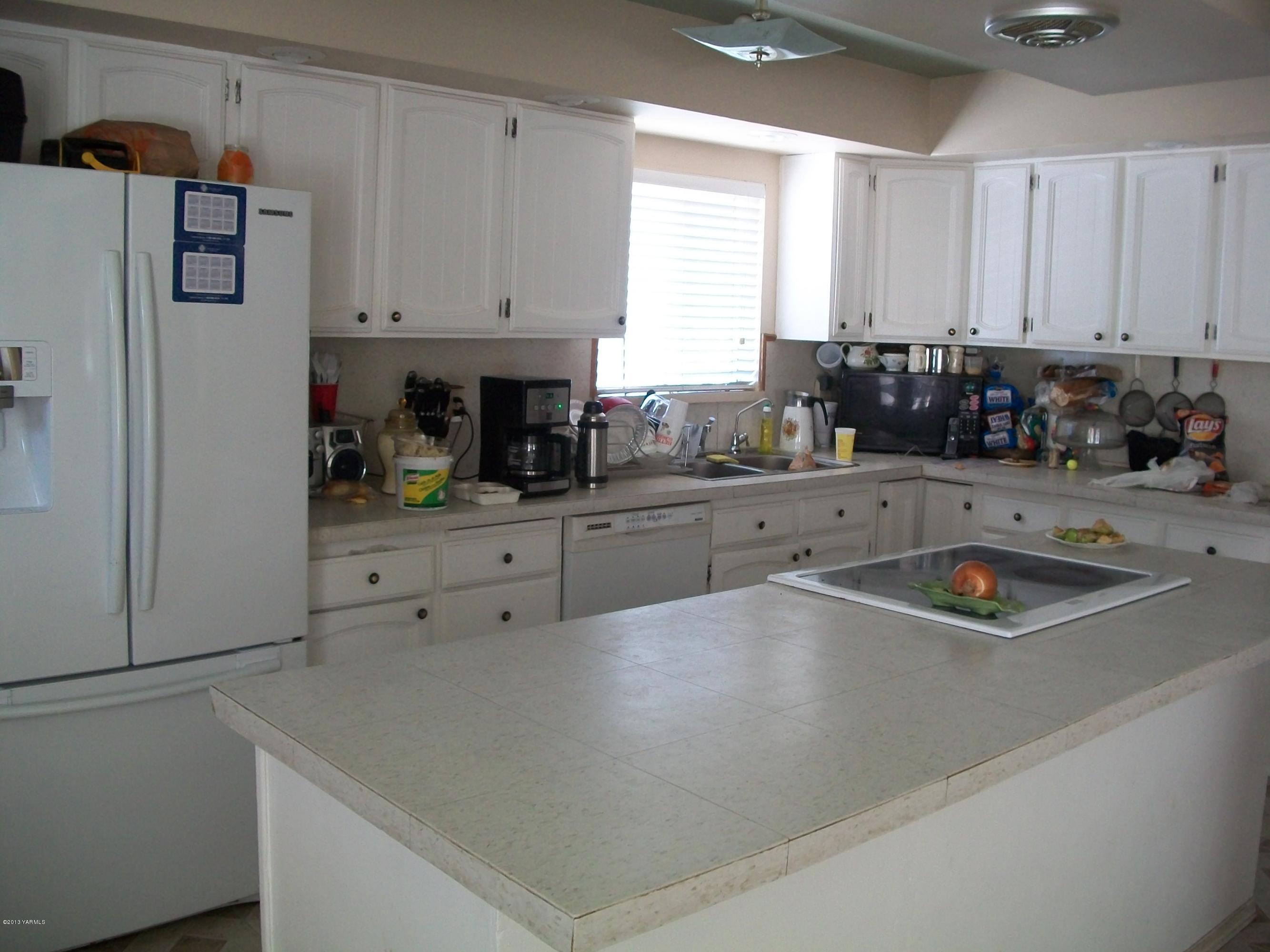 7600 Fort Road Wapato, WA 98951 - Photo 35 of 50 a kitchen with stainless steel appliances a sink a stove and white cabinets