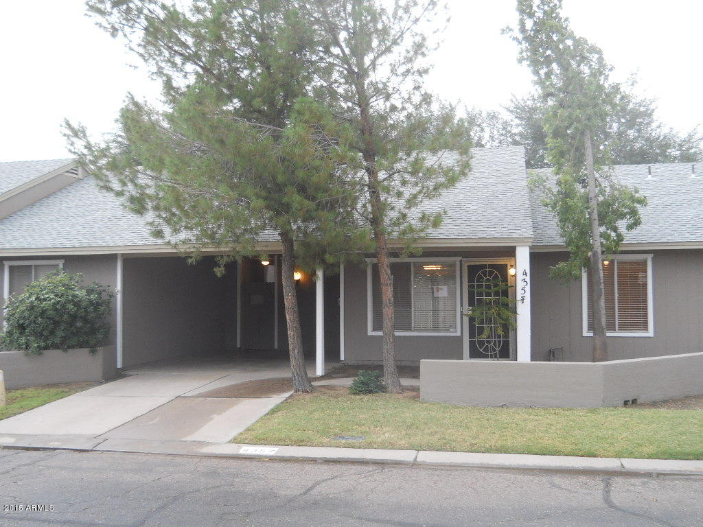 a view of a brick house with a large windows and plants