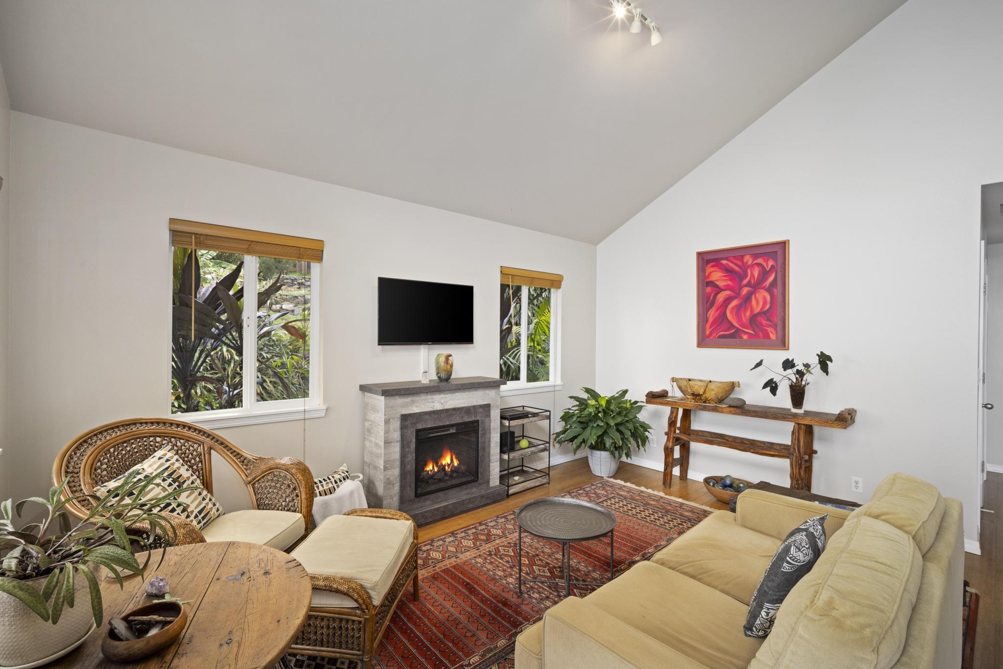 75 Ainakula Road, Unit A Kula, HI 96790 - Photo 11 of 45 a living room with furniture a flat screen tv and a fireplace