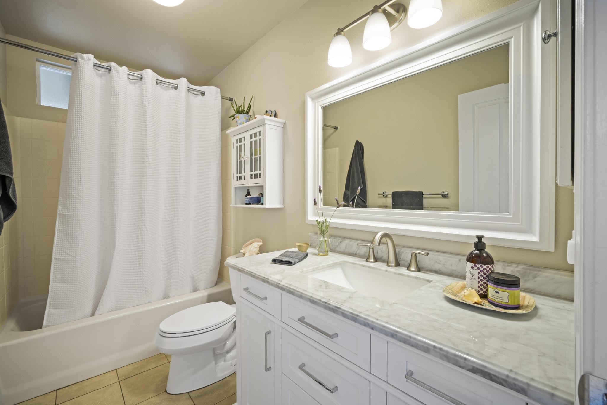 75 Ainakula Road, Unit A Kula, HI 96790 - Photo 24 of 45 a bathroom with a granite countertop sink a toilet and a mirror