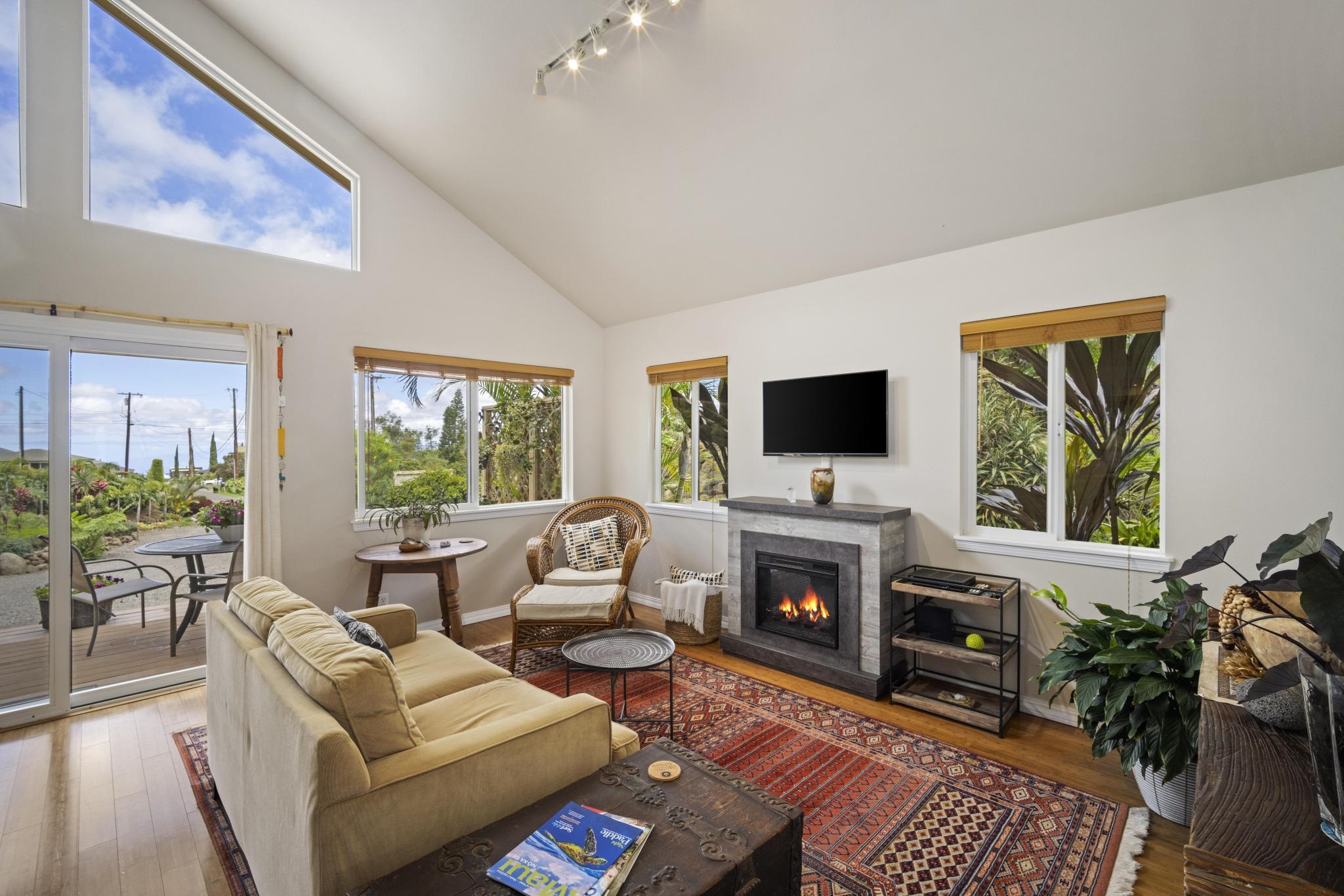 75 Ainakula Road, Unit A Kula, HI 96790 - Photo 10 of 45 a living room with furniture a flat screen tv and a fireplace