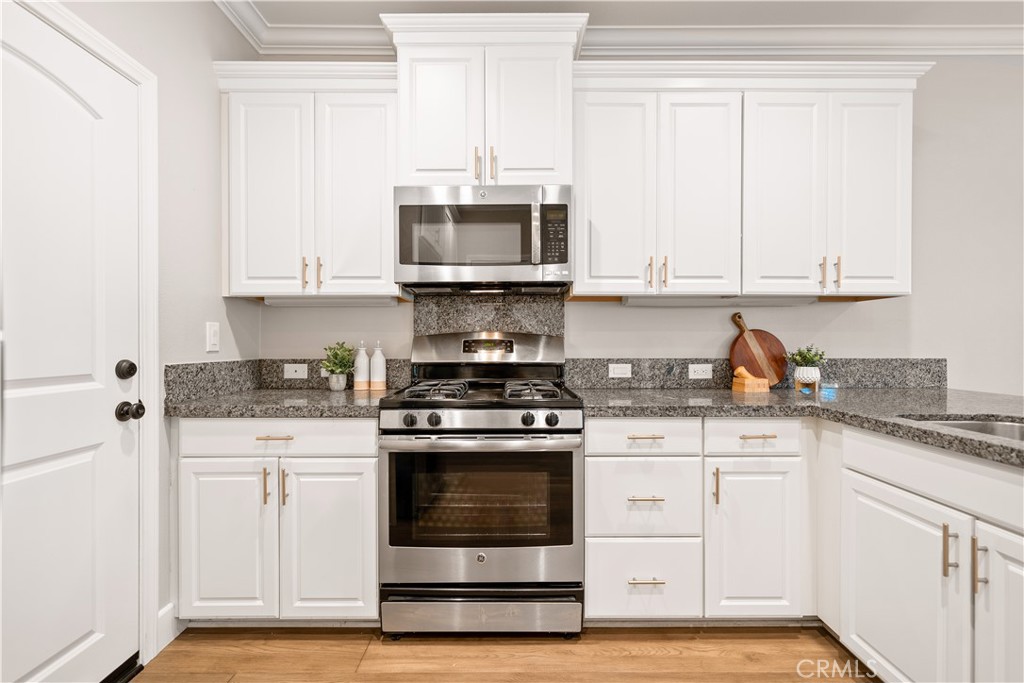 200 Rose Arch Irvine, CA 92620 - Photo 14 of 39 a kitchen with stainless steel appliances granite countertop a stove and white cabinets