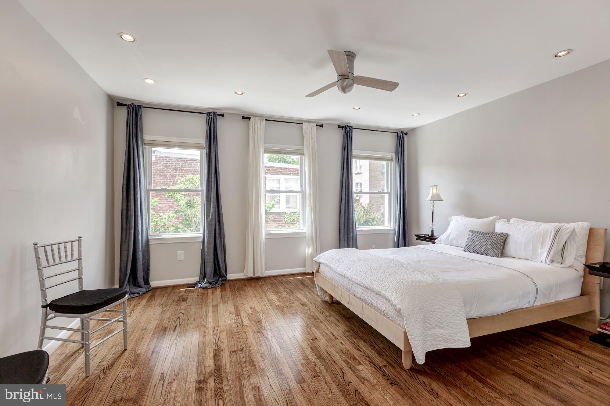 1910 17th Street Northwest Washington, DC 20009 - Photo 17 of 30 a bedroom with a large bed chandelier and a window