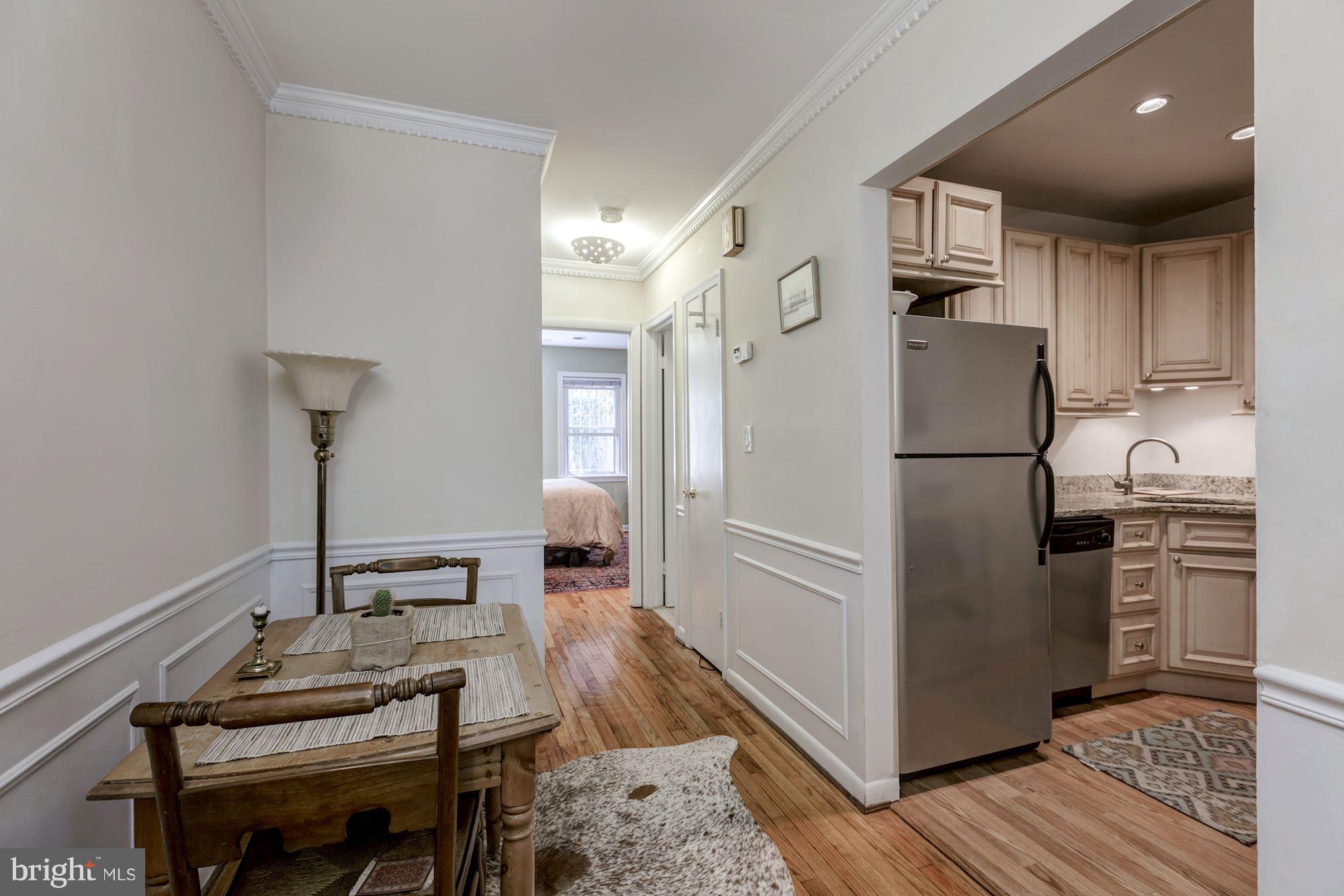 1910 17th Street Northwest Washington, DC 20009 - Photo 22 of 30 a kitchen with a refrigerator a stove and a dining table with wooden floor