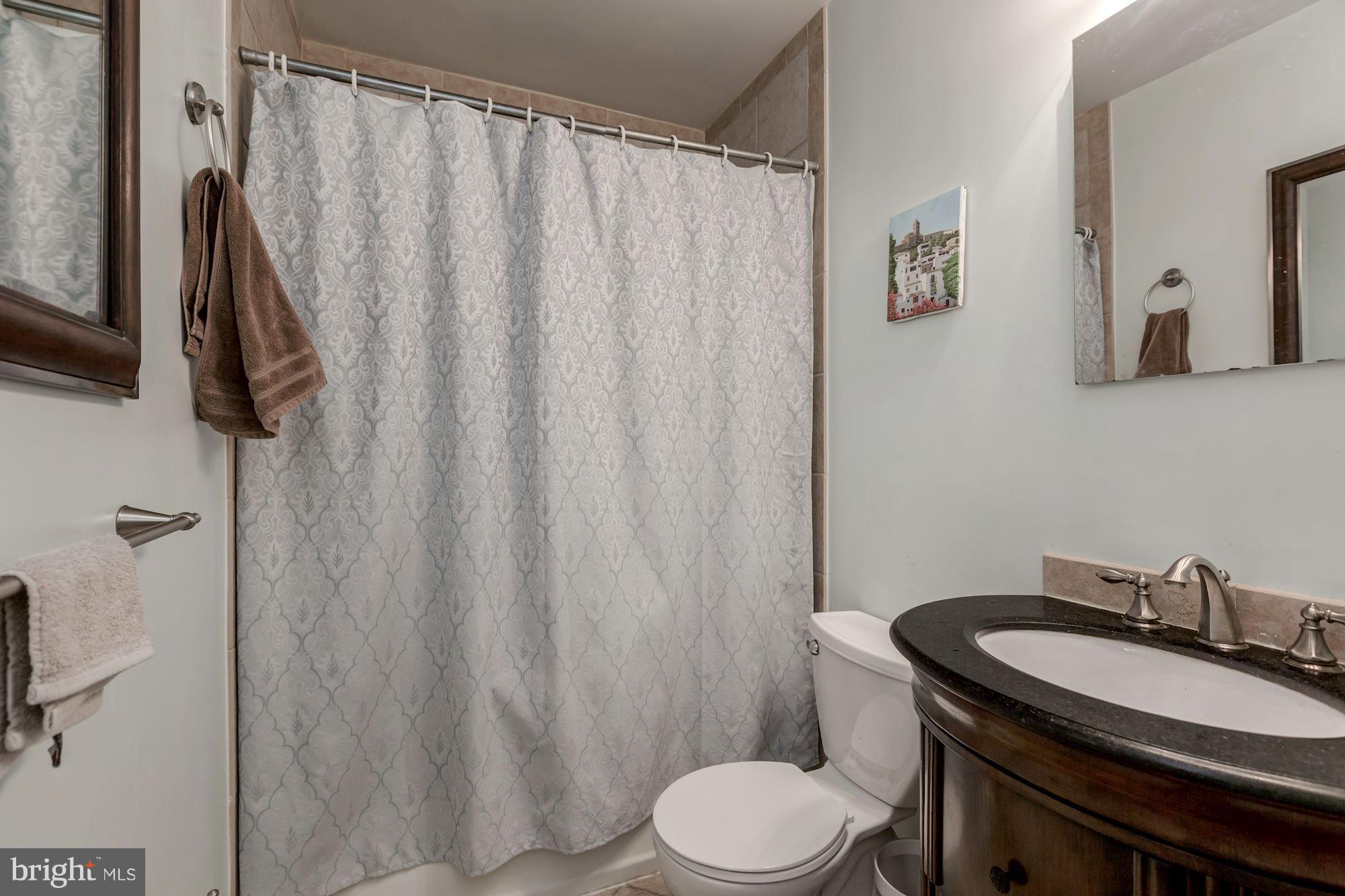1910 17th Street Northwest Washington, DC 20009 - Photo 25 of 30 a bathroom with a granite countertop sink toilet and a mirror