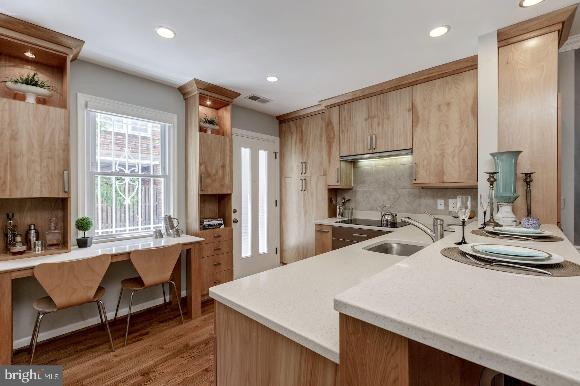 1910 17th Street Northwest Washington, DC 20009 - Photo 9 of 30 a kitchen with a table chairs refrigerator and cabinets