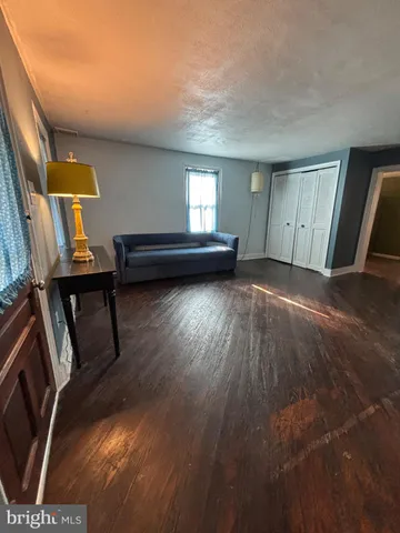 a view of a livingroom with wooden floor and furniture